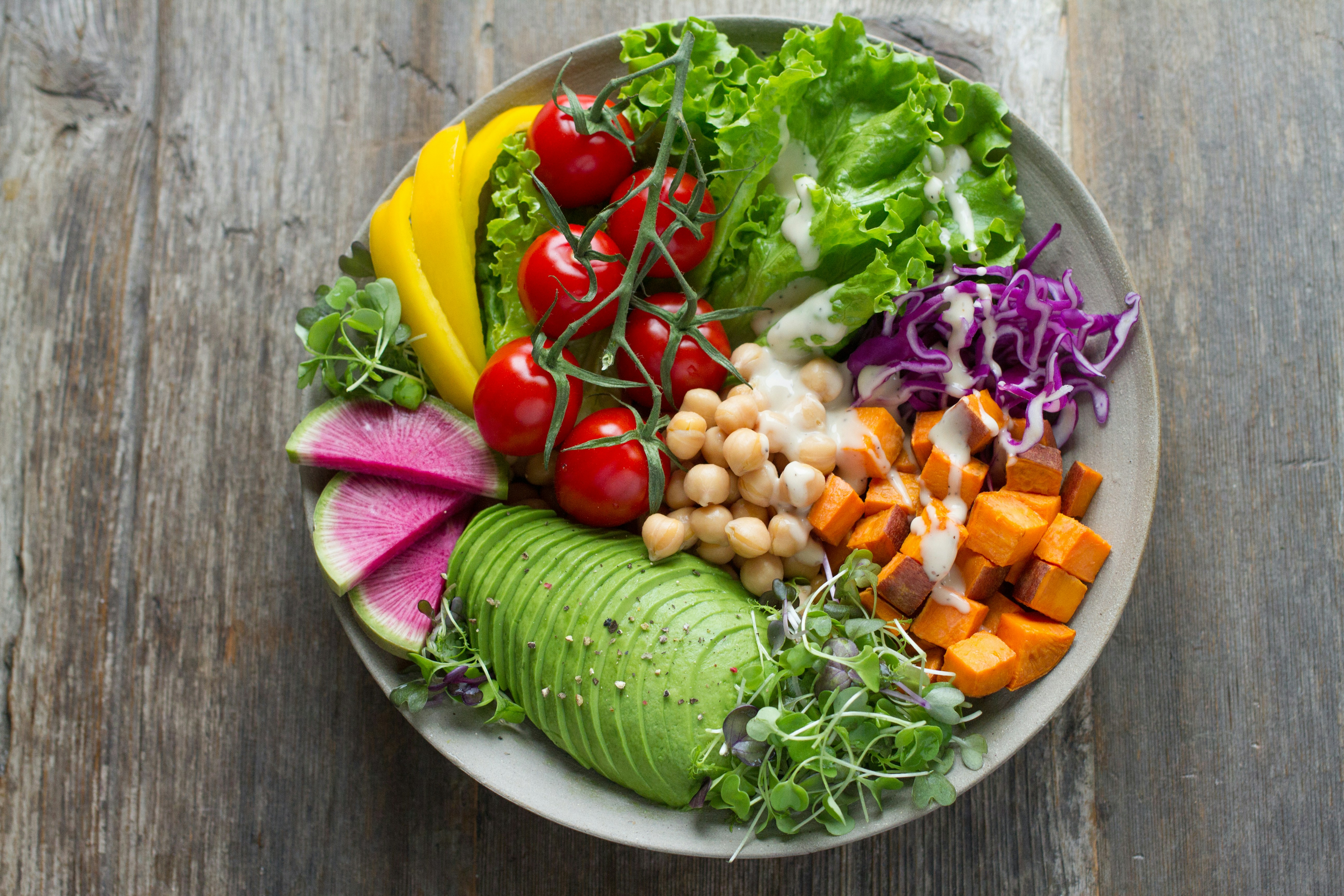 Colorful Buddha bowl with avocado, sweet potato, chickpeas, and fresh vegetables