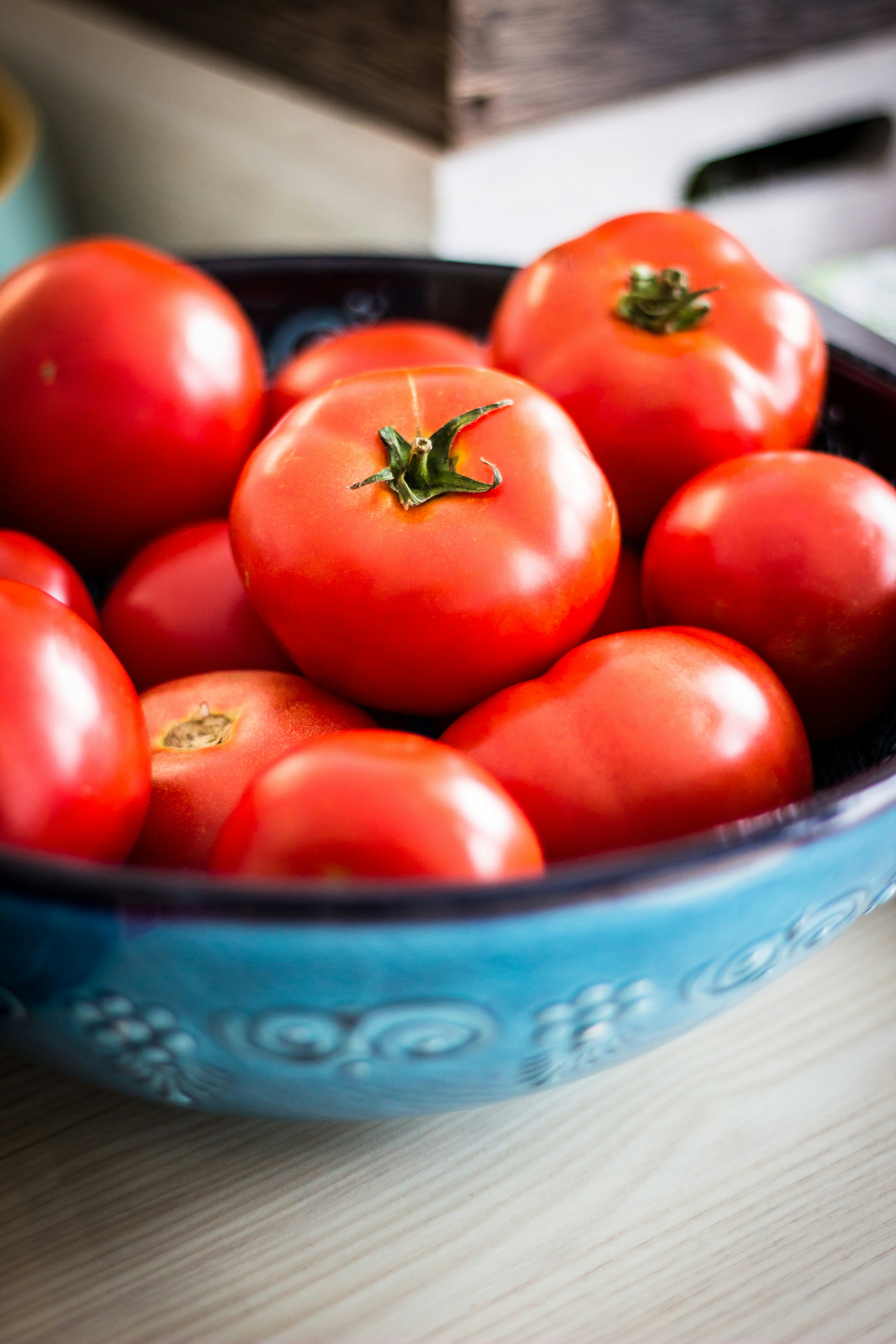 Fresh ripe tomatoes in a decorative blue ceramic bowl