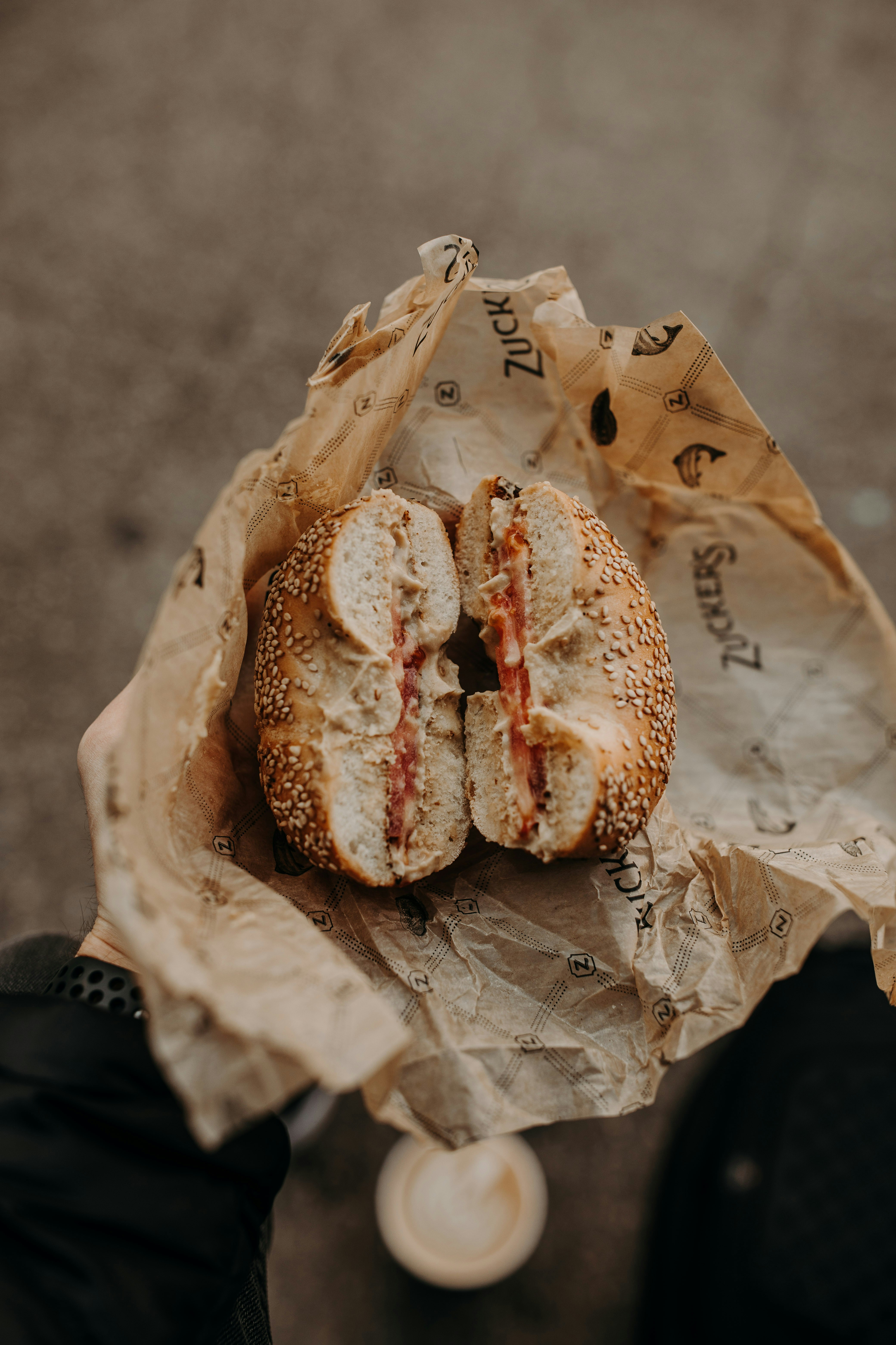 Smoked salmon and cream cheese bagel held in branded paper wrap