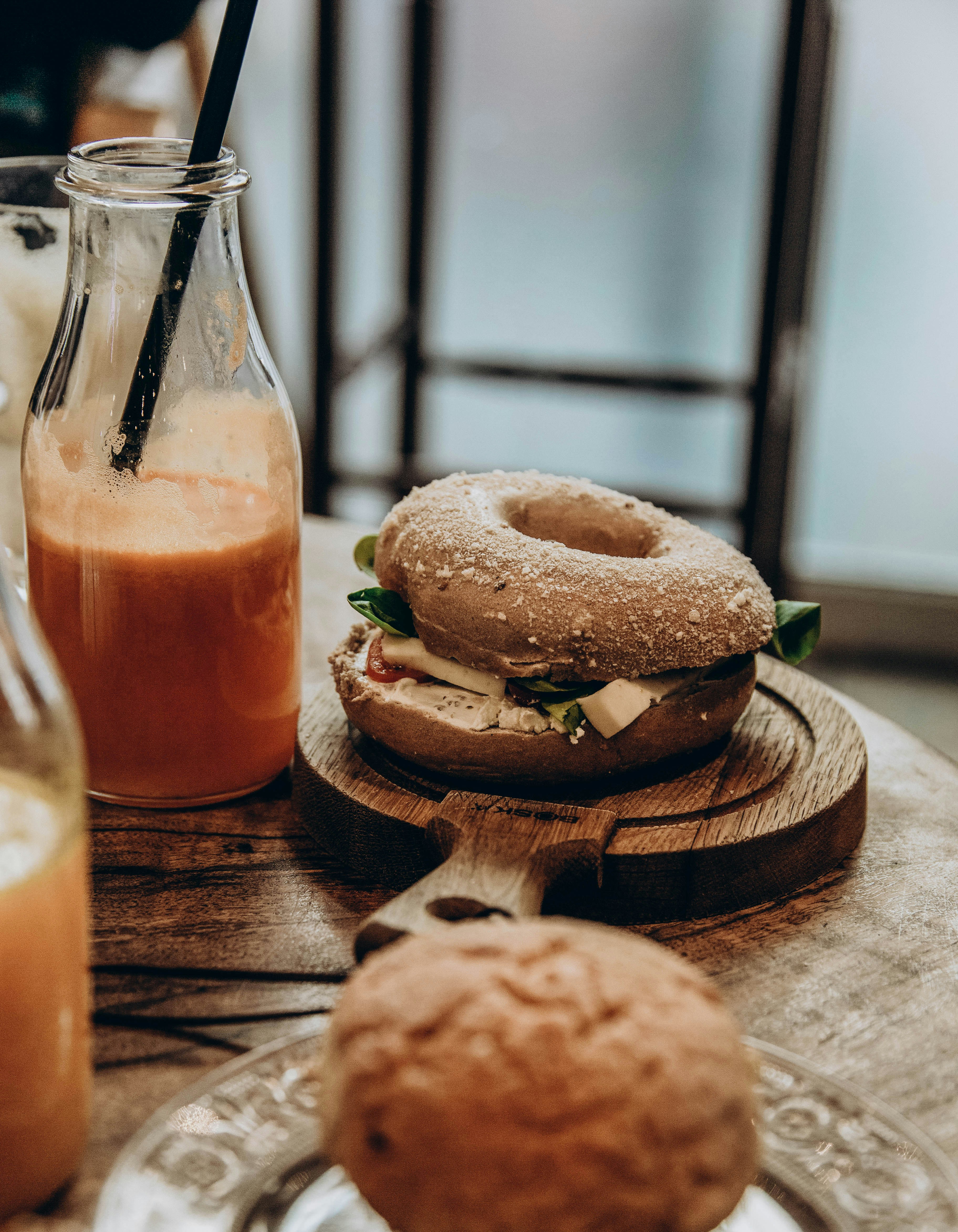 Bagel sandwich with cheese and greens served with fresh orange juice